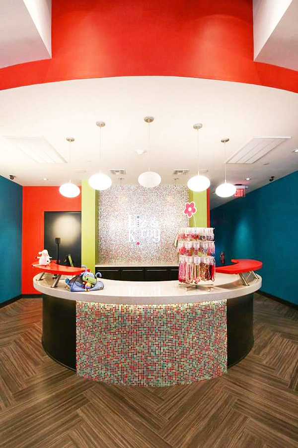 Check out desk at the children's store in a colorful theme of red, white and lime green with mosaic tiles covering the front of the counter