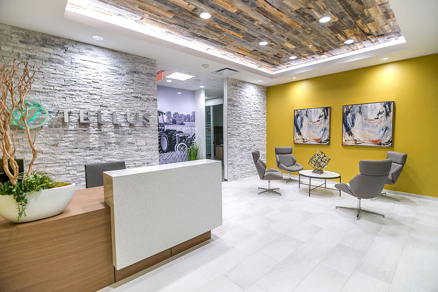 Office lobby with modern white wood floors, textured walls and a bright yellow accent wall with artworks