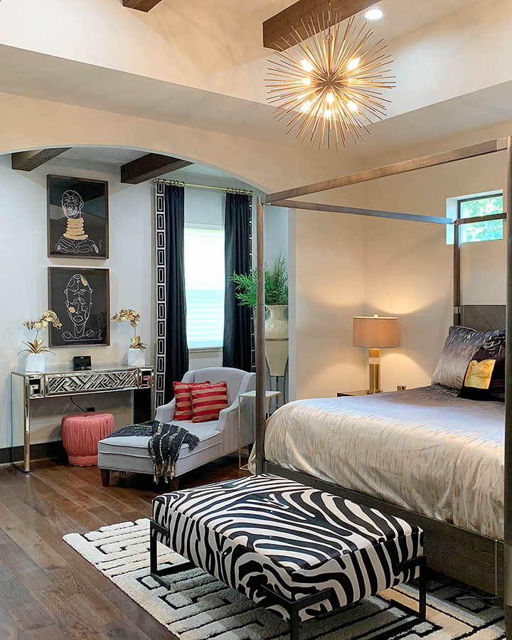 bedroom with four poster bed and black and white zebra inspired furniture