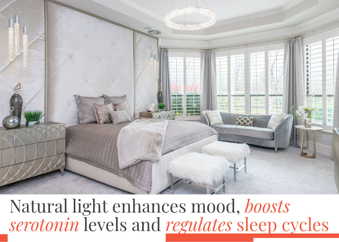 Brightly lit bedroom with large floor to ceiling windows and furniture in earth tones to enhance mood.