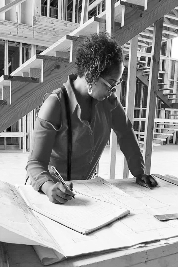 Shundra Harris looking over architectural drawings inside a home under construction.
